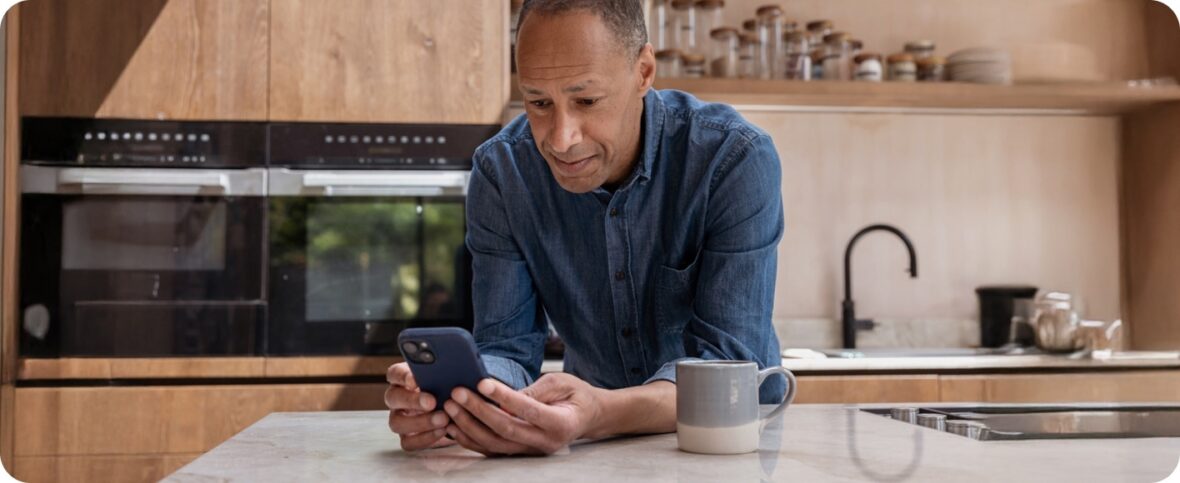 Man on phone leaning over kitchen counter